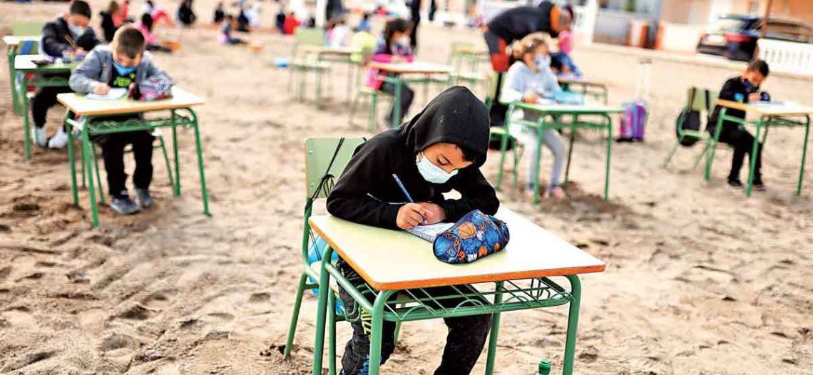 Niños toman clases a la orilla del mar en España