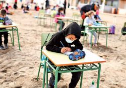 Niños toman clases a la orilla del mar en España