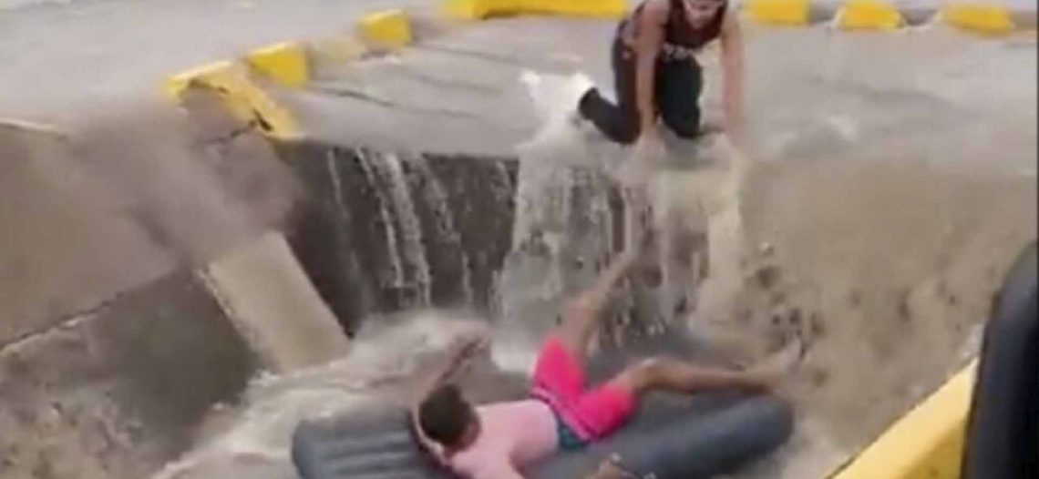 Hombre se avienta en un inflable por una corriente en la calle y se lo traga una coladera